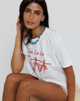 model wearing sea la ie graphic tee with a turquoise necklace on a white background