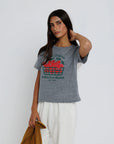 Woman wearing a gray t-shirt with a colorful graphic design on a white background