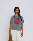 Woman wearing a gray t-shirt with a graphic design on a white background