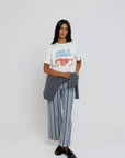 model wearing cool it cowboy tee with stripe pants on a white background