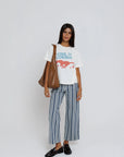 model wearing cool it cowboy tee with stripe pants on a white background