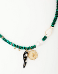 Necklace with green beads and decorative elements on a white background