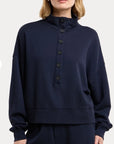 model wearing a navy sweatshirt on a white background