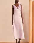 Woman wearing a light purple dress with sequin detailing in a minimalistic setting.
