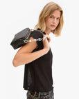 Woman holding a black handbag with a chain strap on a white background