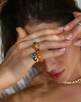 Person wearing multiple rings on fingers with a neutral background