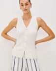 Woman wearing a white sweater vest shirt on a white background front view
