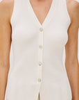 Woman wearing a white sweater vest shirt on a white background detail view