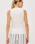 Woman wearing a white sleeveless top and striped pants on a plain background back view