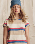 Person wearing a striped shirt and blue beanie against a neutral background