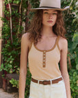 Woman wearing The Henley Slim Tank Stripe and wide-brimmed hat in a natural setting