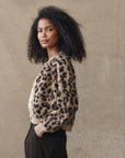 model wearing the leopard windsor cardigan with jeans cream background, side