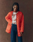 The Quilted Liner Parka on a model with just the orange liner on a brown background