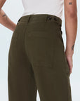 Person wearing olive green pants on a white background