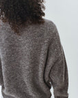 Person wearing a gray sweater against a white background, back