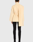 Person wearing a light yellow coat with a belt, black pants, and high heels on a white background back view