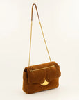 A brown suede shoulder bag with a gold-tone chain strap and a crescent moon-shaped gold clasp, shown against a plain off-white background.