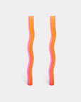 Two wavy, multicolored straws on a light gray background
