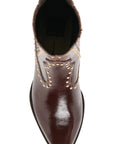 A dark brown leather pointed-toe ankle boot with decorative gold-tone studs and contrast stitching on the side, shown from a top-down view on a white background.