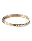 A two-tone metal bangle bracelet with a polished silver outer band and a gold inner band, shown on a clean white background.
