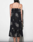 model wearing the Paige Layered Ruffle Midi Dress with strappy sandals on a white background, back