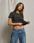 model wearing cher short sleeve vintage black tee with jeans on a cream background