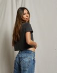 model wearing cher short sleeve vintage black tee with jeans on a cream background