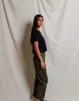 Cher Navy short sleeve tee on a model with green pants and a cream background
