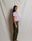 model wearing a purple tee and green pants on a white background, side view