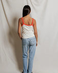 model wearing a tank and jeans against a white background, back view