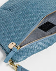A close-up of a woven blue leather shoulder bag with gold-tone hardware, a zippered compartment, and a matching blue leather strap on a white background.