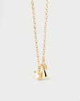 Gold necklace with a small pendant on a light gray background detail view