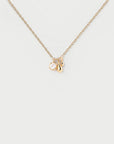 Gold necklace with a small pendant on a light gray background