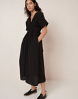 Woman wearing a black dress against a plain background