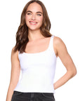 Woman wearing a white tank top and black pants on a white background