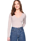 vneck long sleeve top in sandstone on a model wearing jeans with a white background
