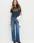 Woman wearing a navy t-shirt and blue jeans on a white background