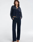 Woman wearing a navy denim outfit on a white background