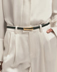 White shirt and beige pants with a black belt featuring The Lady Belt.