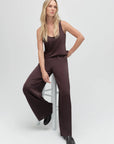 Woman wearing a brown pants and top on a white background