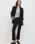 Women wearing black blazer and black pants with white background