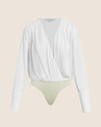A white long-sleeve draped wrap top with a deep V-neckline, styled over a light beige thong, shown against a solid pale beige background.
