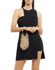 Woman wearing a black dress holding a decorative handbag on a white background