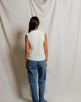 model wearing a white collared shirt with jeans on a white background, back view