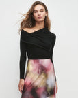 Woman wearing a black top and colorful skirt on a white background