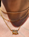Close-up of layered gold necklaces on a person's neck