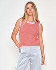 model wearing stripe top with shiny pants on white background
