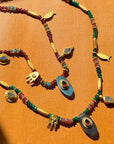 Decorative necklaces with colorful beads and gold accents on an orange background