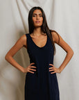 Woman wearing a navy blue dress against a plain background