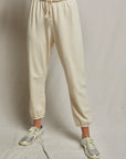 Beige sweatpants worn by a person on a plain background
